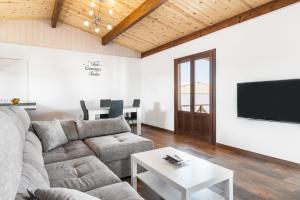 a living room with a couch and a tv and a table at Casa Hefestión in Conil de la Frontera