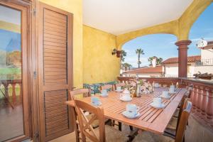 - une table en bois avec des tasses et des tasses sur le balcon dans l'établissement Casa Albina, à San Teodoro