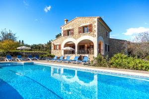 a villa with a swimming pool in front of a house at Villa Rote in Campanet