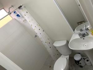 a small bathroom with a toilet and a sink at Home near Pimentel beach with parking in Chiclayo