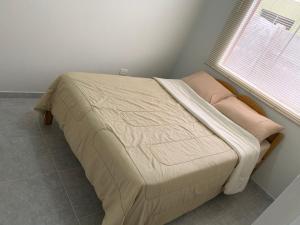 Bett in einem Schlafzimmer mit Fenster in der Unterkunft Home near Pimentel beach with parking in Chiclayo