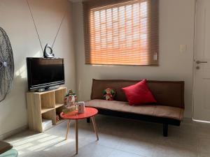 ein Wohnzimmer mit einem Sofa und einem TV in der Unterkunft Home near Pimentel beach with parking in Chiclayo
