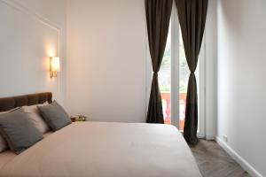 ボーソレイユにあるBeautiful Apartment next to Monte Carloのベッドルーム(大きな白いベッド1台、窓付)