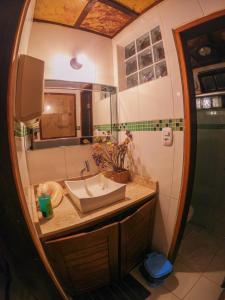 uma casa de banho com um lavatório e um espelho em Pousada Bons Lençóis em Lençóis