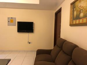 a living room with a couch and a flat screen tv at New Royal Mark Hotel Apartments in Dubai