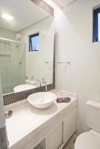 a bathroom with a sink and a toilet and a mirror at Charmoso e Aconchegante in Recife