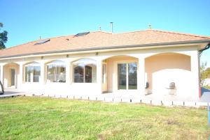 a large white house with a grass field at VILLA KÉRINÉ in Valencin