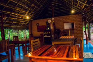a restaurant with wooden tables and chairs in a room at Star Light Cabanas & Restaurant in Tangalle