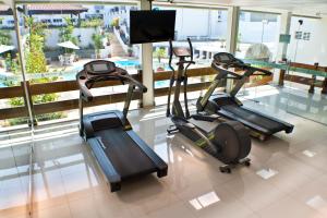 three exercise bikes in a gym with a window at Posseidon Hotel in Imperatriz