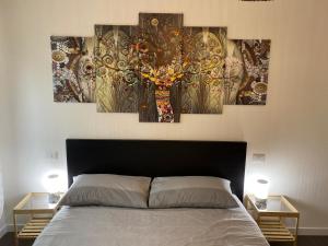 a bedroom with a bed with four paintings on the wall at Smart house in Turin