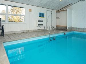 Skødshoved StrandにあるFour-Bedroom Holiday home in Knebel 6の- 青い水のスイミングプール(客室内)