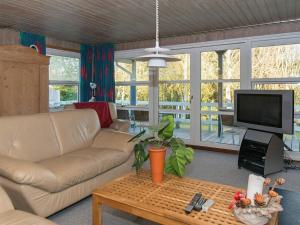 sala de estar con sofá y TV en Four-Bedroom Holiday home in Knebel 6, en Skødshoved Strand