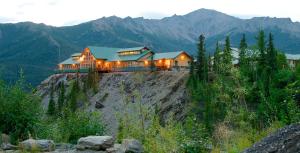 a house on top of a hill with mountains at Grande Denali Lodge in McKinley Park