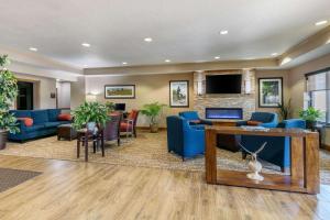a living room with blue furniture and a tv at Comfort Suites Hopkinsville near Fort Campbell in Hopkinsville