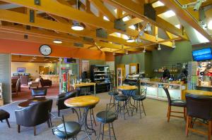 a restaurant with stools and tables and a counter at Denali Bluffs Hotel by Aspen Hotels in McKinley Park