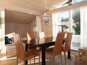 a dining room with a black table and chairs at 6 person holiday home in Knebel in Ørby