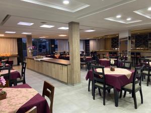 a restaurant with tables and chairs and a bar at Augusto Palace Hotel in Marabá