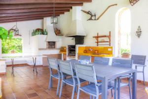 a kitchen with a table and chairs and a stove at Villa Can Curt in Pollença