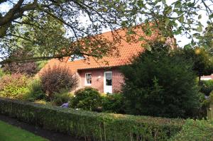a brick house with an orange roof at Ferienwohnung Anni, 65325 in Moormerland