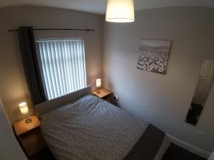 ein Schlafzimmer mit einem Bett und einem Fenster mit zwei Lampen in der Unterkunft Templemore Townhouse in Belfast