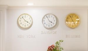 three clocks on a wall with the words happy new year at De Lavender Bangkok Hotel in Bangkok