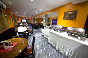 New Royal Mark Hotel Apartments في دبي: مطعم بطاولات وكراسي طويلة في الغرفة