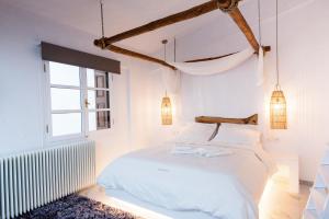 a white bedroom with a bed and a window at Blue Mountain Guesthouse by Seablue in Arachova