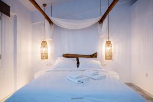 a bedroom with a white bed with two towels on it at Blue Mountain Guesthouse by Seablue in Arachova