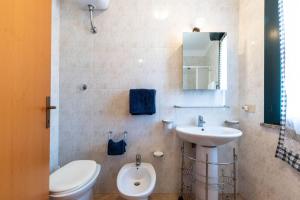 Un baño con un inodoro blanco y un lavabo. en Appartamenti Cavour Codice E, en Villasimius