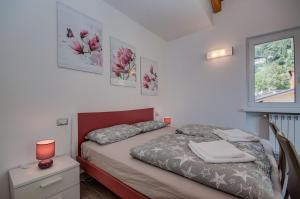 mała sypialnia z łóżkiem i oknem w obiekcie Appartamento Giada w Tremosine Sul Garda