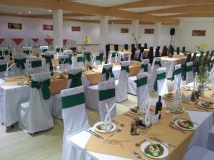 - une salle de banquet avec des tables blanches et des archets verts dans l'établissement Hotel Astore Suites, à Antofagasta