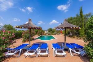 a group of chairs and umbrellas next to a pool at Geminis in Llucmajor