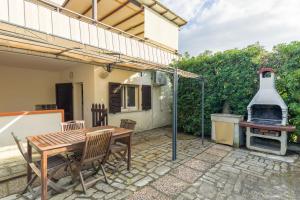 a patio with a table and chairs and a grill at Monolocale casa Lucia in Campo nell'Elba