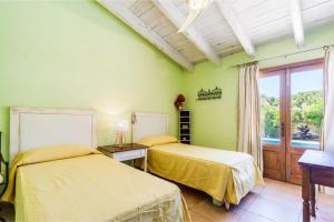 Dos camas en una habitación con paredes verdes. en Villa Cuxac De Na Joana, en Pollensa 17 fotos más