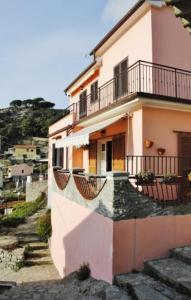 a pink house with stairs leading up to it at Appartamento Seccheto Mare in Seccheto