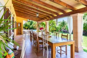 comedor al aire libre con mesa de madera y sillas en Villa Cuxac De Na Joana, en Pollensa