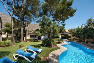 a yard with two lounge chairs and a swimming pool at Can Domingo in Pollença
