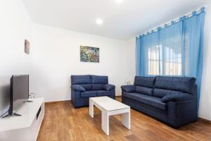 チクラナ・デ・ラ・フロンテーラにあるVilla Costa Luzのリビングルーム(青いソファ2台、テレビ付)