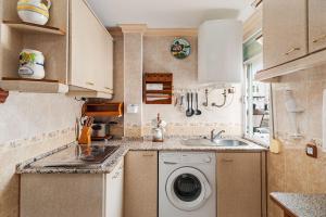 a small kitchen with a washing machine and a sink at Apartamento Oliva in Barbate