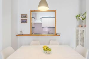 a white table with a bowl of bananas on it at Apartamento Bateles in Conil de la Frontera