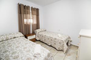 コニル・デ・ラ・フロンテーラにあるApartamento Chiclana 1のベッドルーム1室(ベッド2台付)、窓(カーテン付)