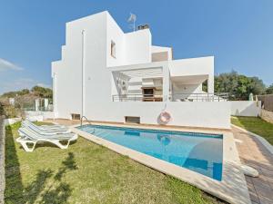 a villa with a swimming pool in front of a house at Montevela in Cala d´Or