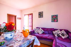 ein Wohnzimmer mit einem lila Sofa und einem Tisch in der Unterkunft Villetta Ivana in Marciana