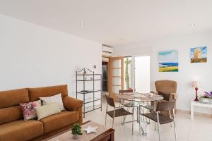 ein Wohnzimmer mit einem Sofa und einem Tisch in der Unterkunft Apartamento Cañada Honda Conil in Conil de la Frontera