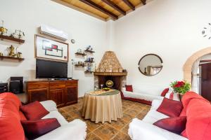 a living room with red and white furniture and a tv at Finca Esplendor in Campos