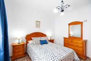 コニル・デ・ラ・フロンテーラにあるApartamento Virtudesのベッドルーム1室(鏡付きベッド1台、ドレッサー付)