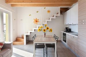 una cucina con tavolo, sedie e scala di Casa Vacanze Marisol a Tremosine Sul Garda