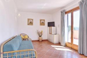 a living room with a blue couch and a television at Villa Vanna Trilo -quadrilocale in Capoliveri