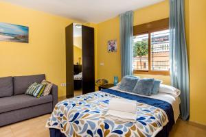 a bedroom with a bed and a couch and a window at Apartamento estudio in Málaga
