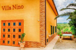 um edifício amarelo com uma porta vermelha e uma mesa em Villa Nino em Petacciato